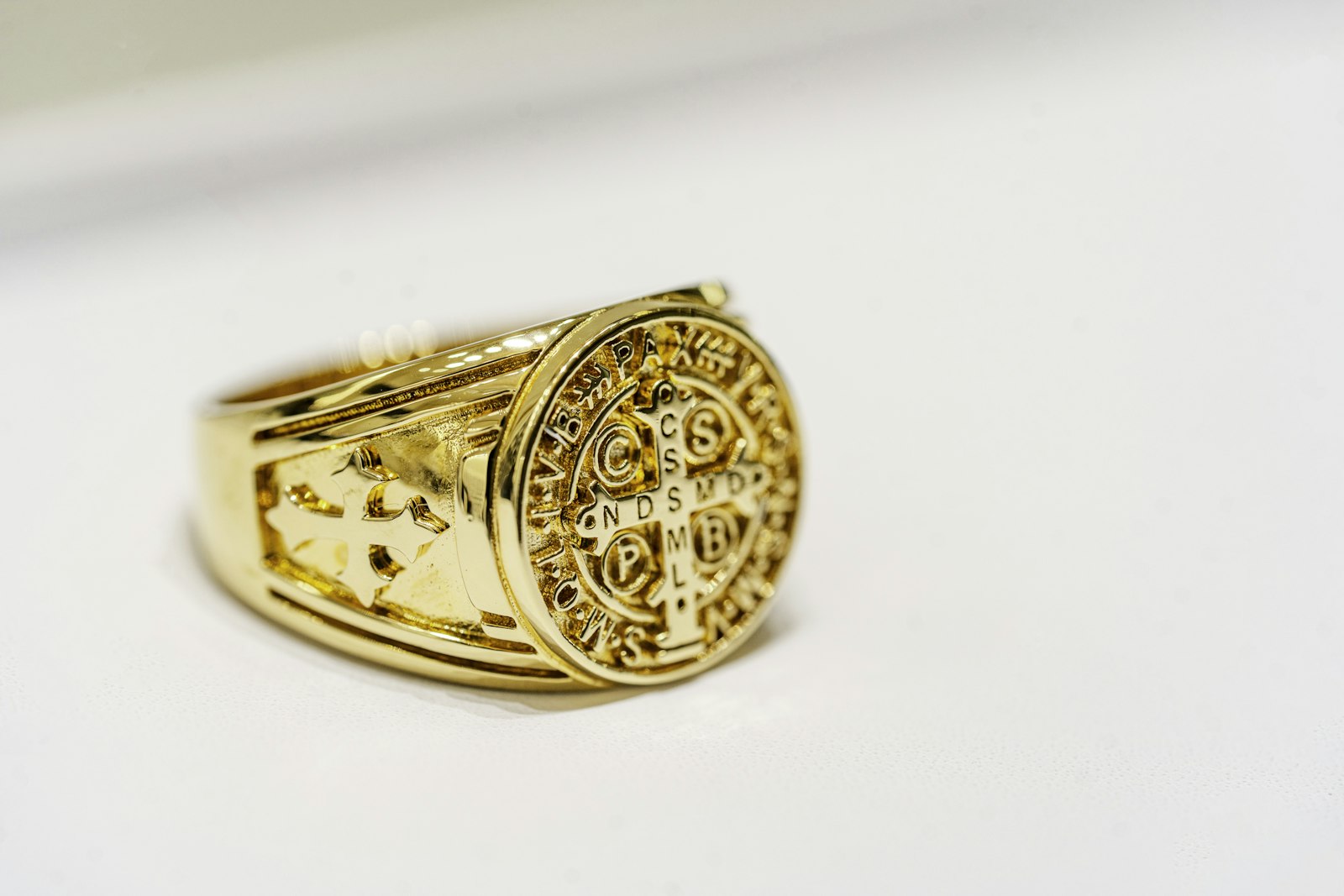 A gold ring photographed close up on a white surface A gold ring photographed close up on a white surface